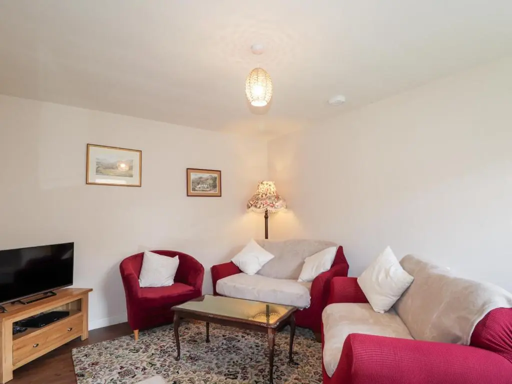 a living room with two couches and a tv at Loubcroy Farm House in Lairg