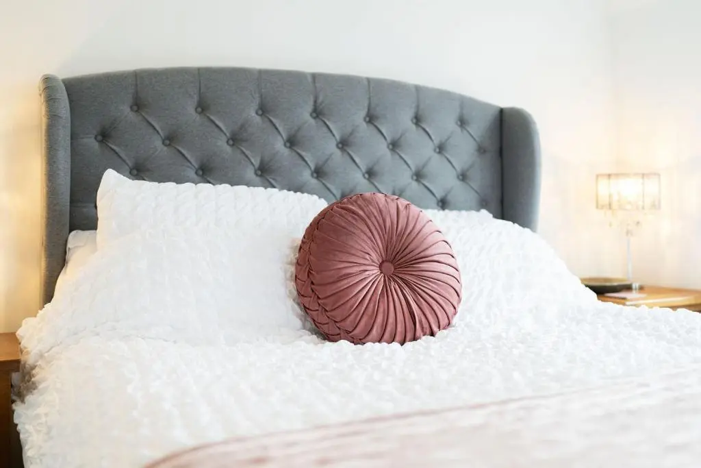 a pink pillow sitting on top of a bed at The Corner House in Hopeman
