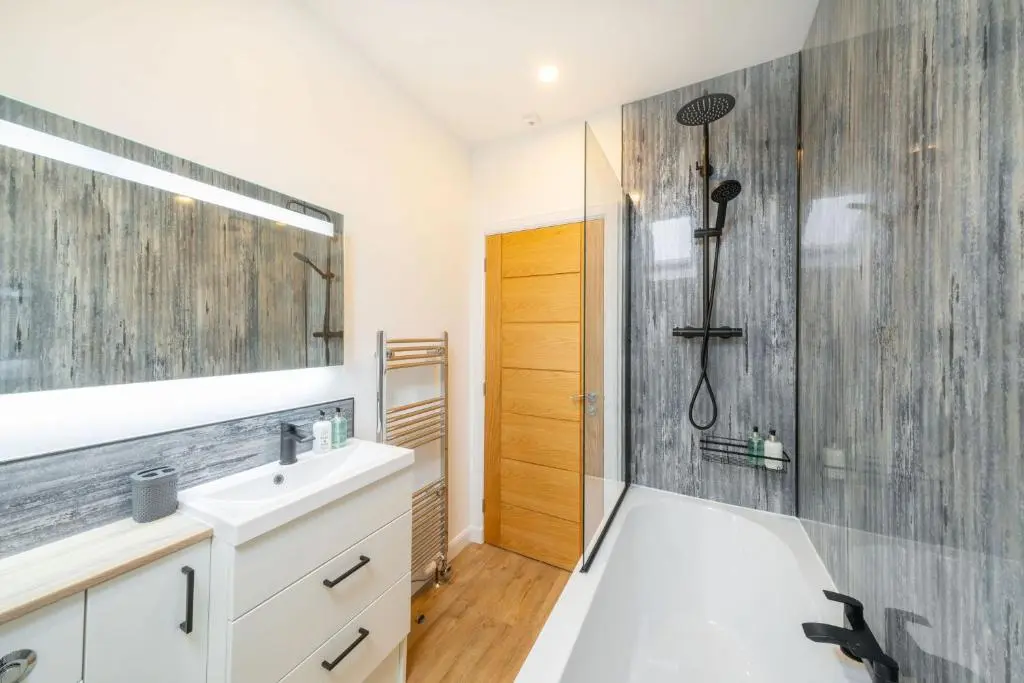 a bathroom with a shower and a sink and a mirror at The Corner House in Hopeman