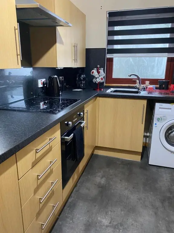 a kitchen with a sink and a washing machine at Cameron apartment Loch Ness in Fort Augustus