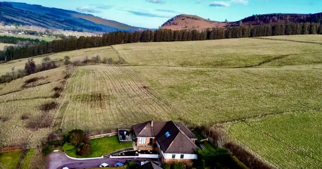an aerial view of a house in a field at Eldon Lea in Strathpeffer