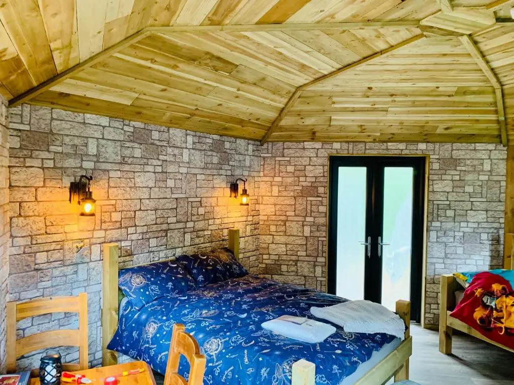 a bedroom with a bed in a brick wall at Hagrids Hut - Off grid Cabin - no electricity or running water in Munlochy