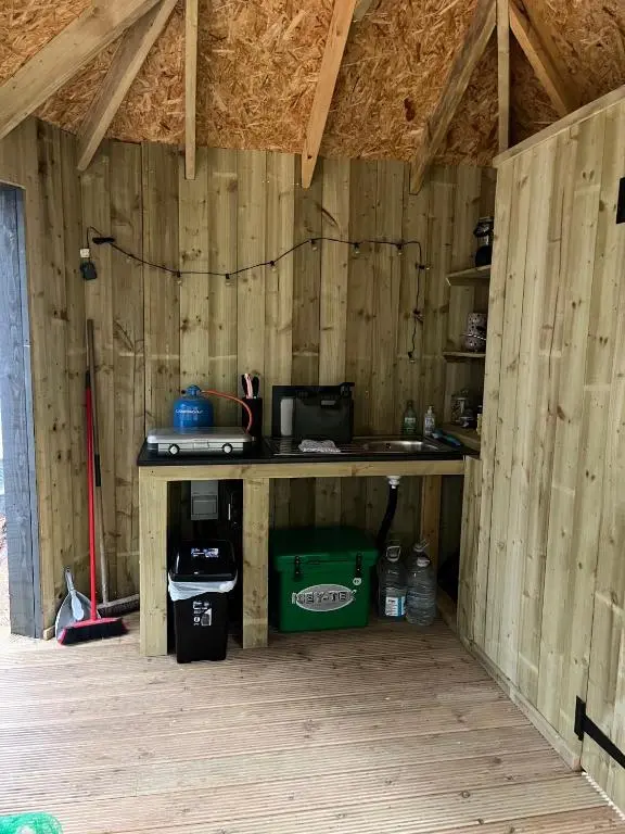 a room with a counter in a wooden building at Hagrids Hut - Off grid Cabin - no electricity or running water in Munlochy
