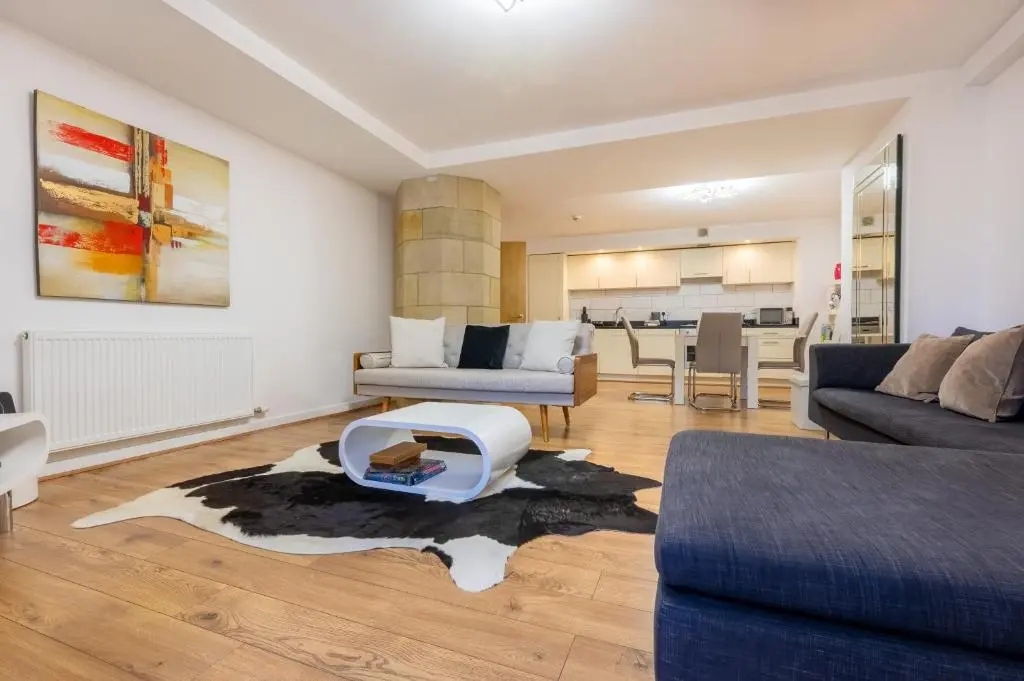 a living room with a couch and a table at AC19 Lower North Aisle - Luxury Self Catering 2 Bedroom Apartment in Fort Augustus