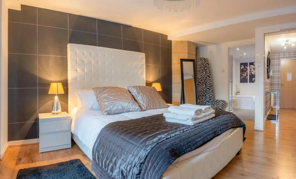 a bedroom with a bed with towels on it at AC19 Lower North Aisle - Luxury Self Catering 2 Bedroom Apartment in Fort Augustus