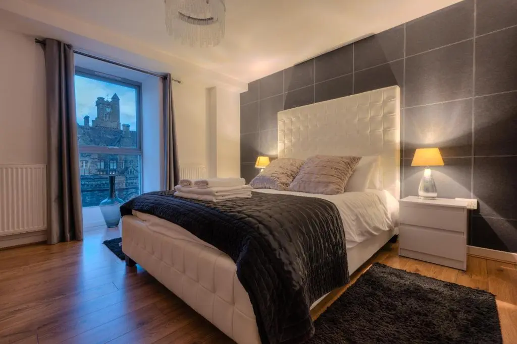 a bedroom with a large bed and a large window at AC19 Lower North Aisle - Luxury Self Catering 2 Bedroom Apartment in Fort Augustus