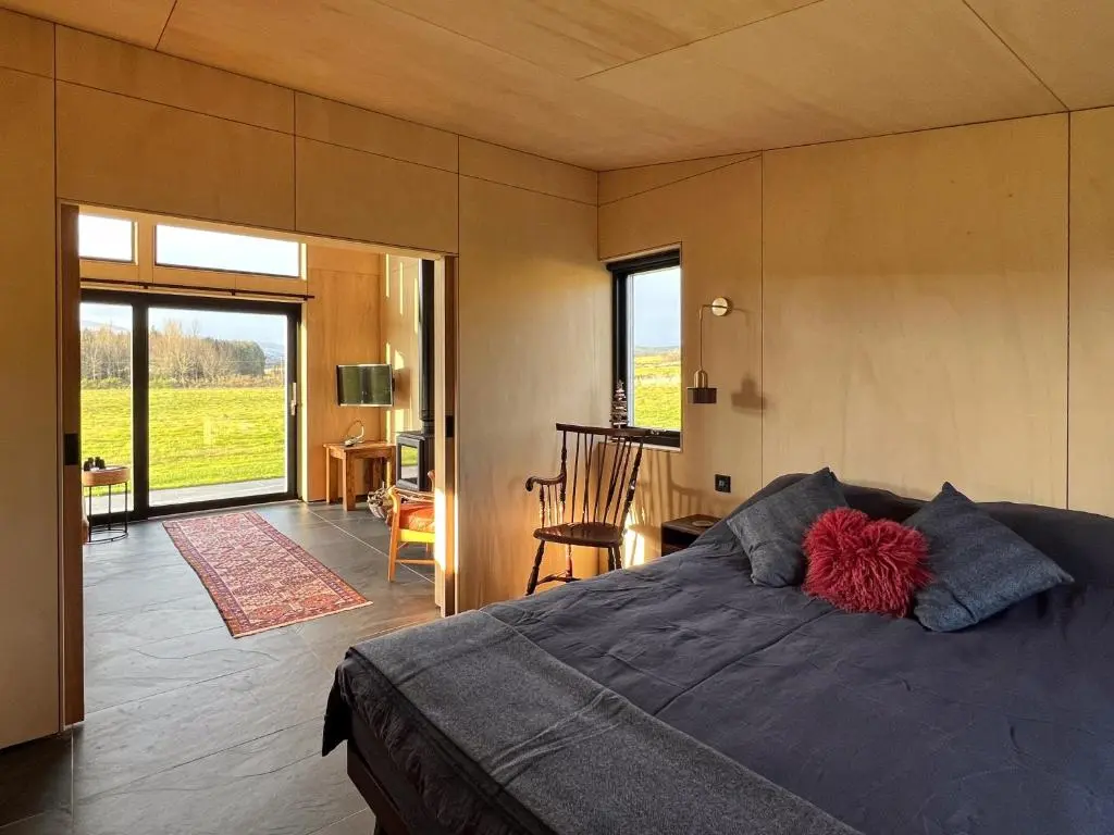 a bedroom with a bed with a red ball on it at Tillyfruskie Farm Holiday Cabin, Finzean in Banchory