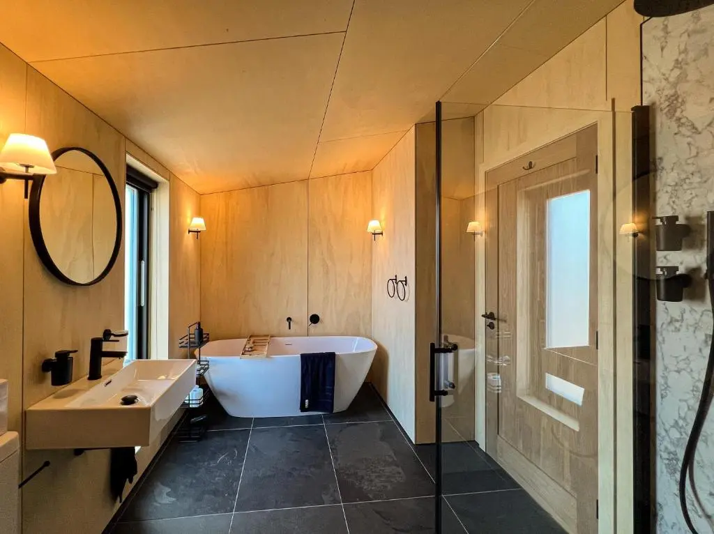 a bathroom with a tub and a sink and a shower at Tillyfruskie Farm Holiday Cabin, Finzean in Banchory