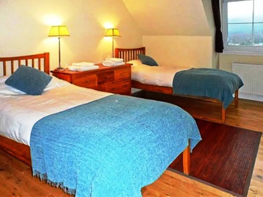 a hotel room with two beds and a window at Hillview House Hostel Inverness in Inverness