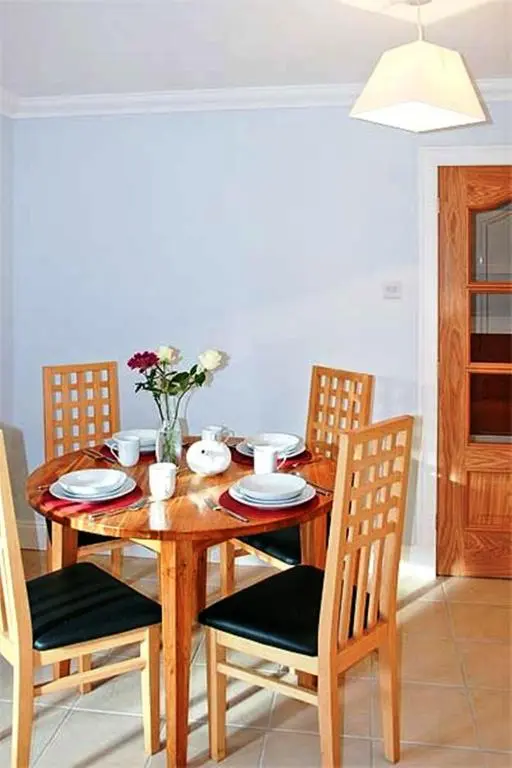 a wooden table with chairs and a dining room at Hillview House Hostel Inverness in Inverness