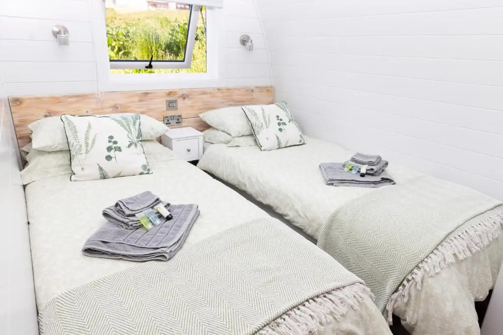 two beds sitting next to each other in a room at Byrnside Lodge in Latheron