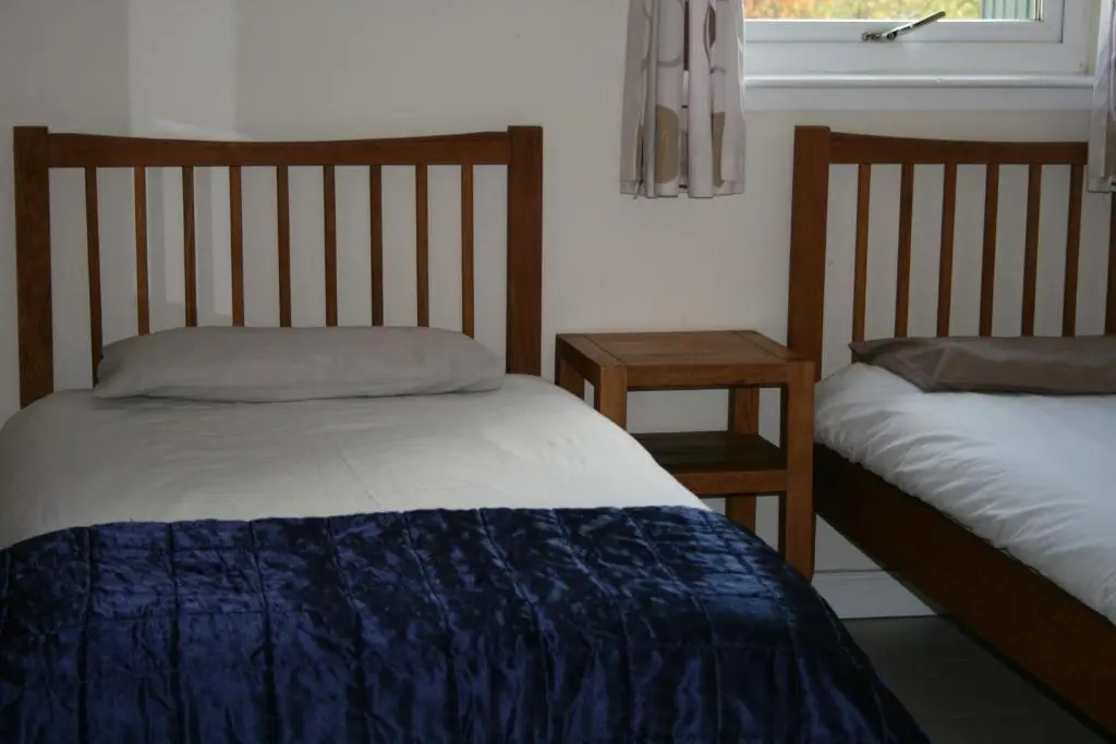 a bedroom with two beds and a window at BCC Loch Ness Hostel in Bearnock