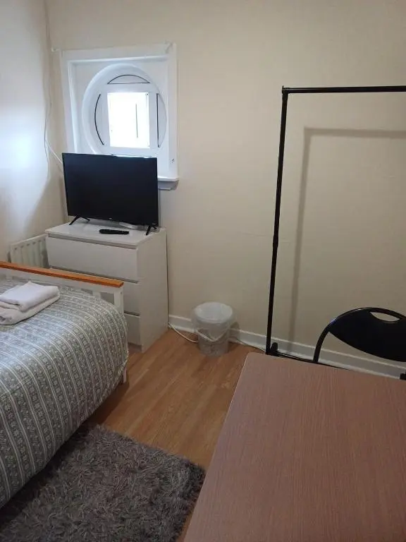 a bedroom with a bed and a tv and a window at Inverthorn House in Inverness