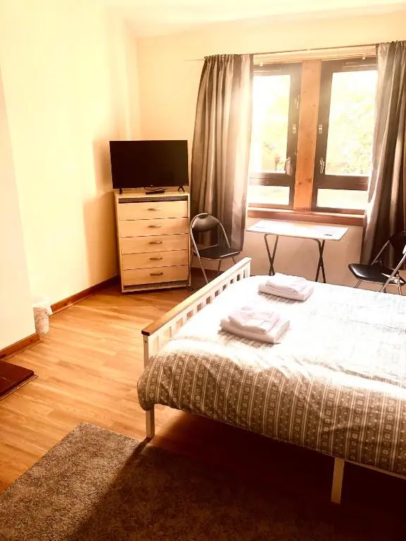 a bedroom with a bed and a dresser and a television at Inverthorn House in Inverness