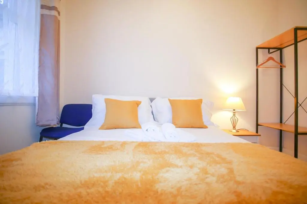 a bedroom with a large bed and a blue chair at Lochlash 3 Bedroom House Inverness in Inverness
