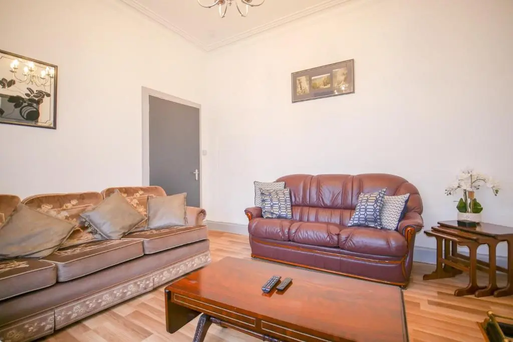 a living room with two leather couches and a table at Telford Rd 5 Bedroom House Inverness in Inverness