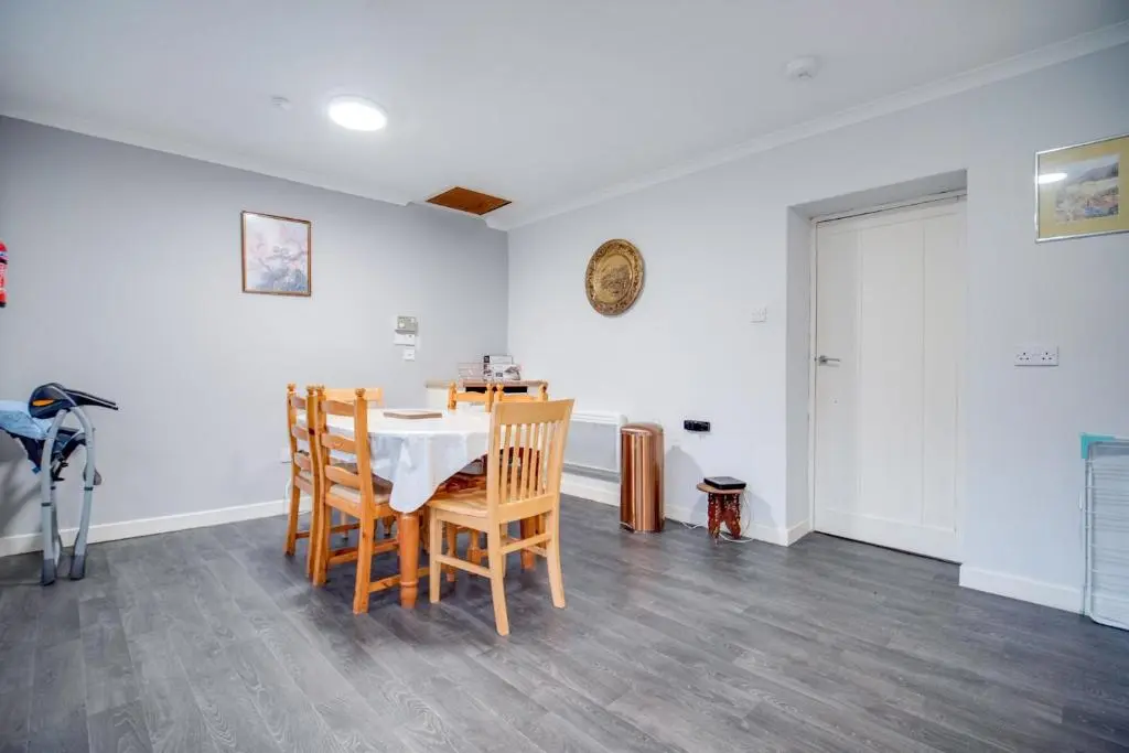 a dining room with a table and chairs at Novar 4 Bedroom House Alness in Inverness