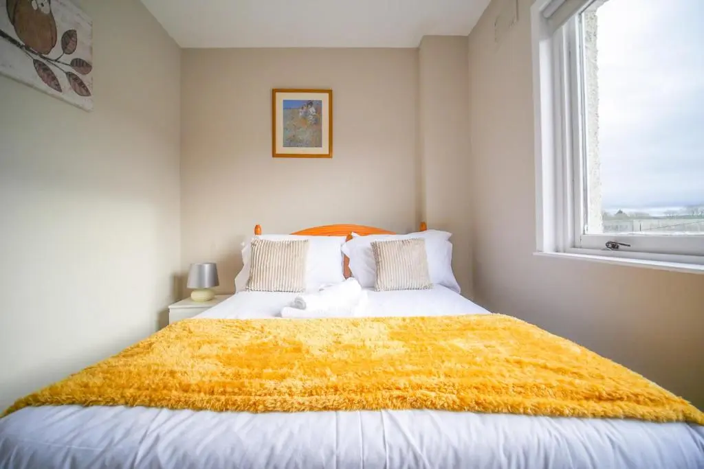 a bedroom with a bed with a yellow blanket on it at Telford St 4 Bedroom House Inverness in Inverness