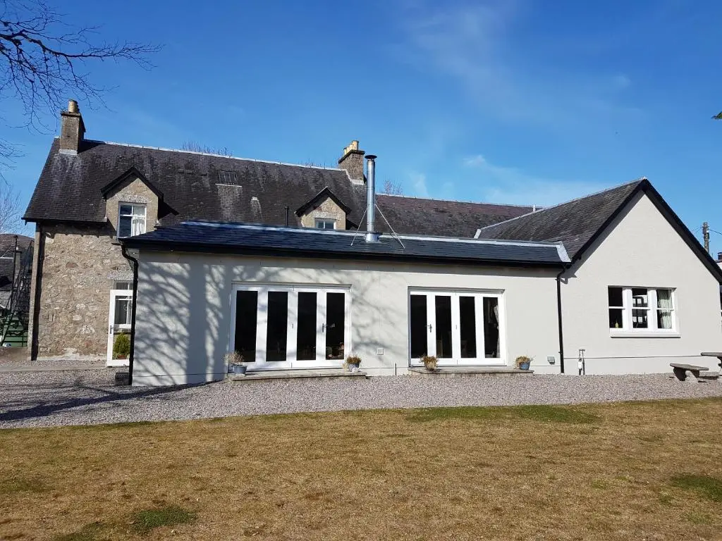 a white house with a black roof at Loch Ness Guest House in Fort Augustus
