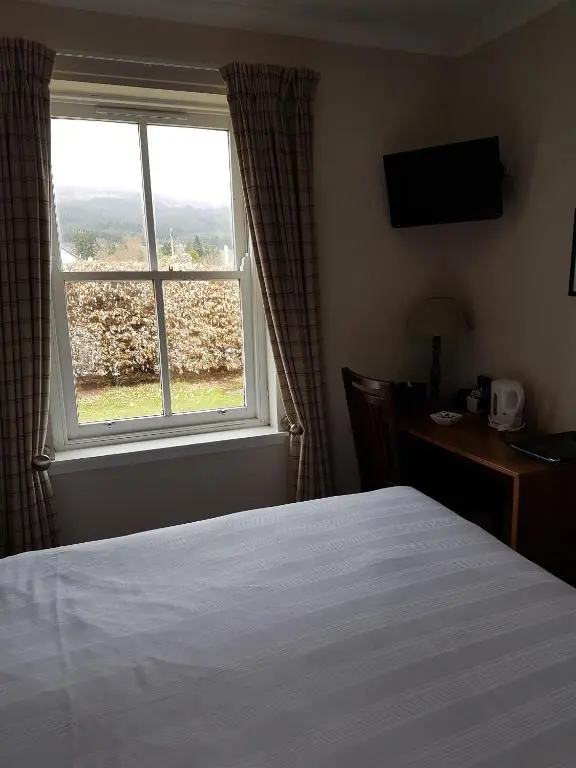 a hotel room with a bed and a window at Loch Ness Guest House in Fort Augustus
