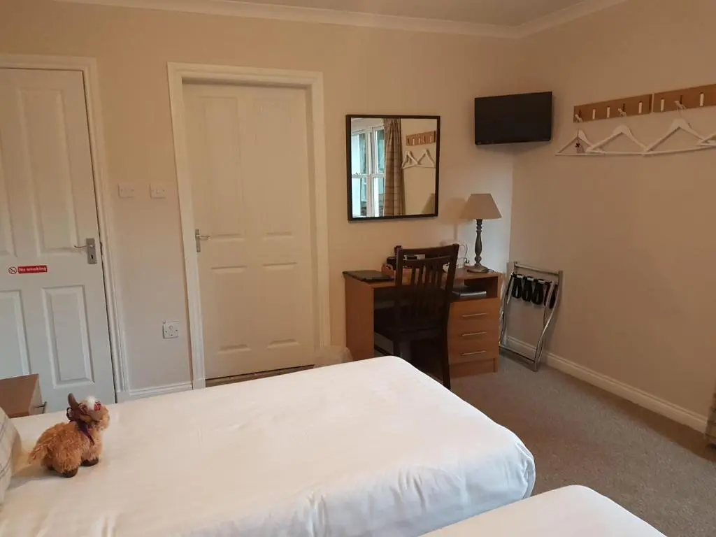a small stuffed animal sitting on a bed in a bedroom at Loch Ness Guest House in Fort Augustus