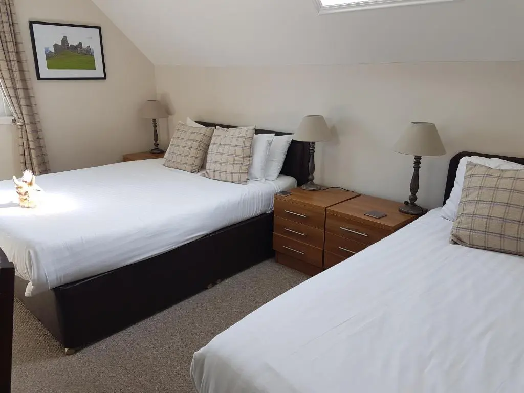 a bedroom with two beds and two night stands at Loch Ness Guest House in Fort Augustus