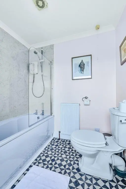 a white bathroom with a toilet and a shower at Kinkell House Rooms in Cononbridge