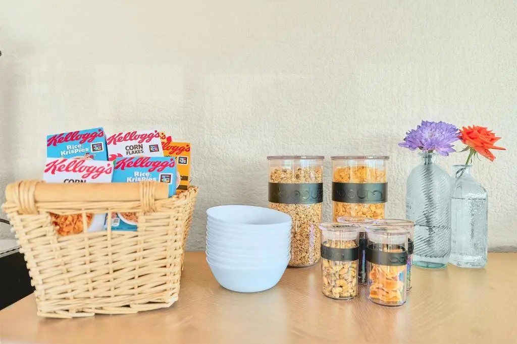 a table with bowls and containers of food and flowers at Kinkell House Rooms in Cononbridge