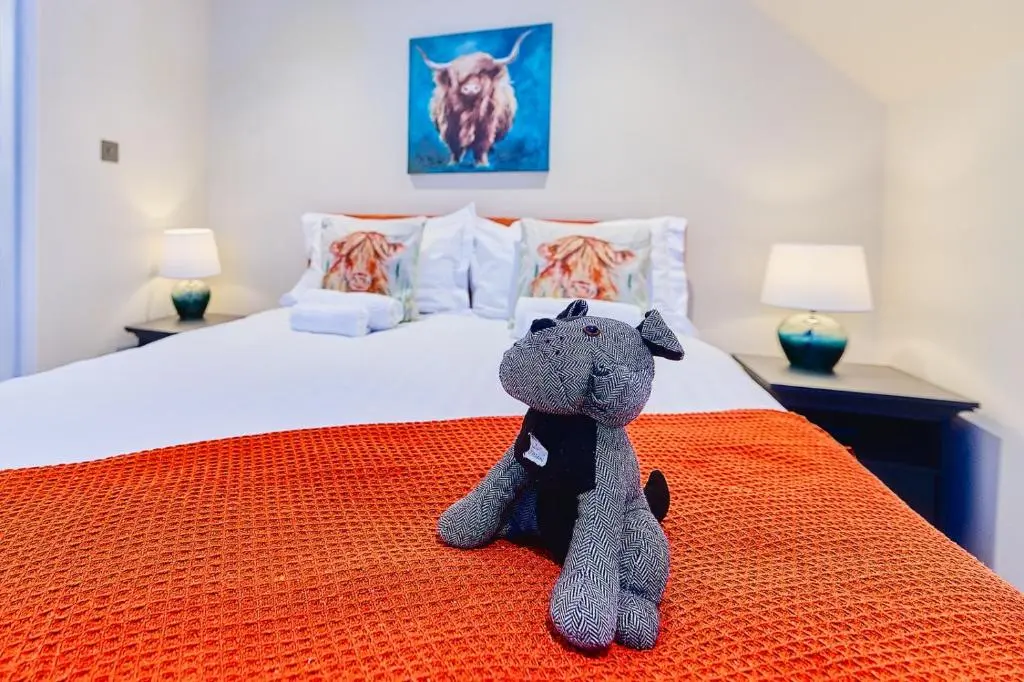 a stuffed animal sitting on top of a bed at Kinkell House Rooms in Cononbridge