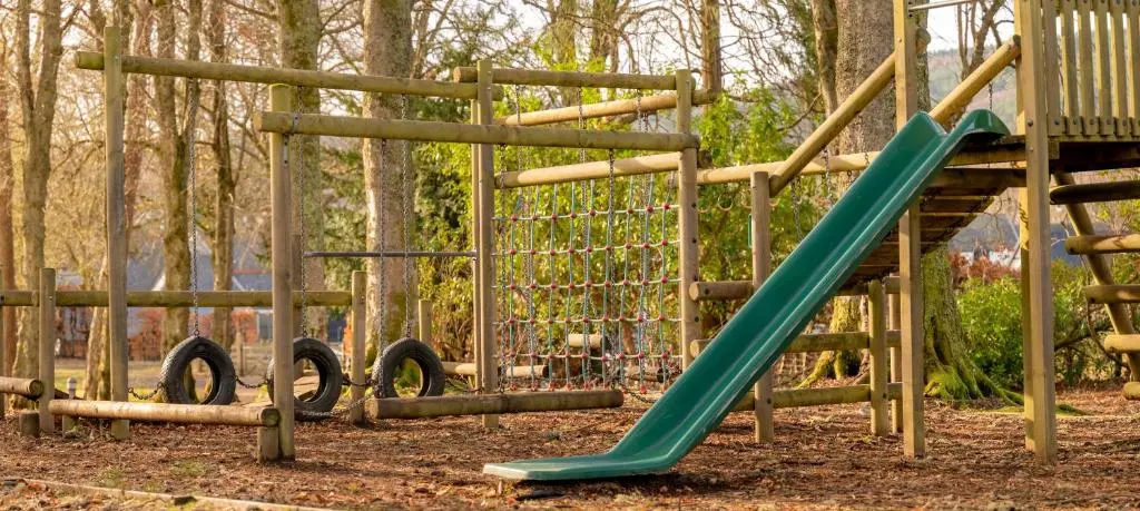 a playground with a green slide in a park at Major's Apartment 3 Bedroom Self Catering Property in historic Abbey in Fort Augustus