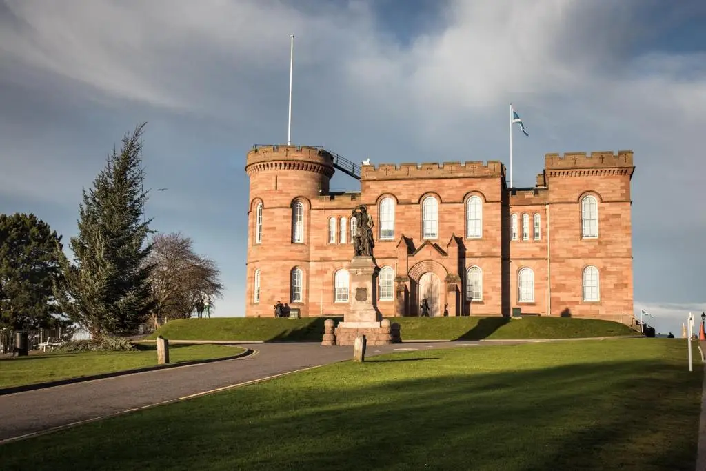 a large brick building with a flag on top of it at Bed on the Brae in Inverness