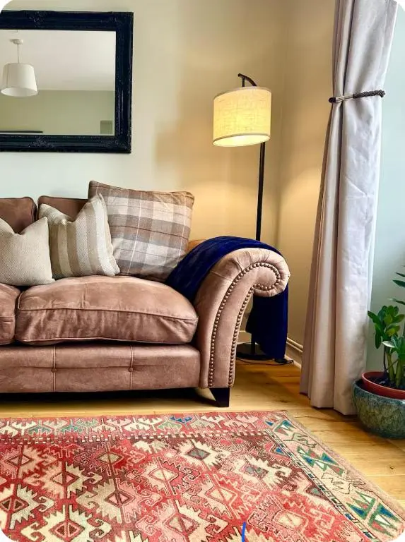 a living room with a couch and a lamp at Bed on the Brae in Inverness