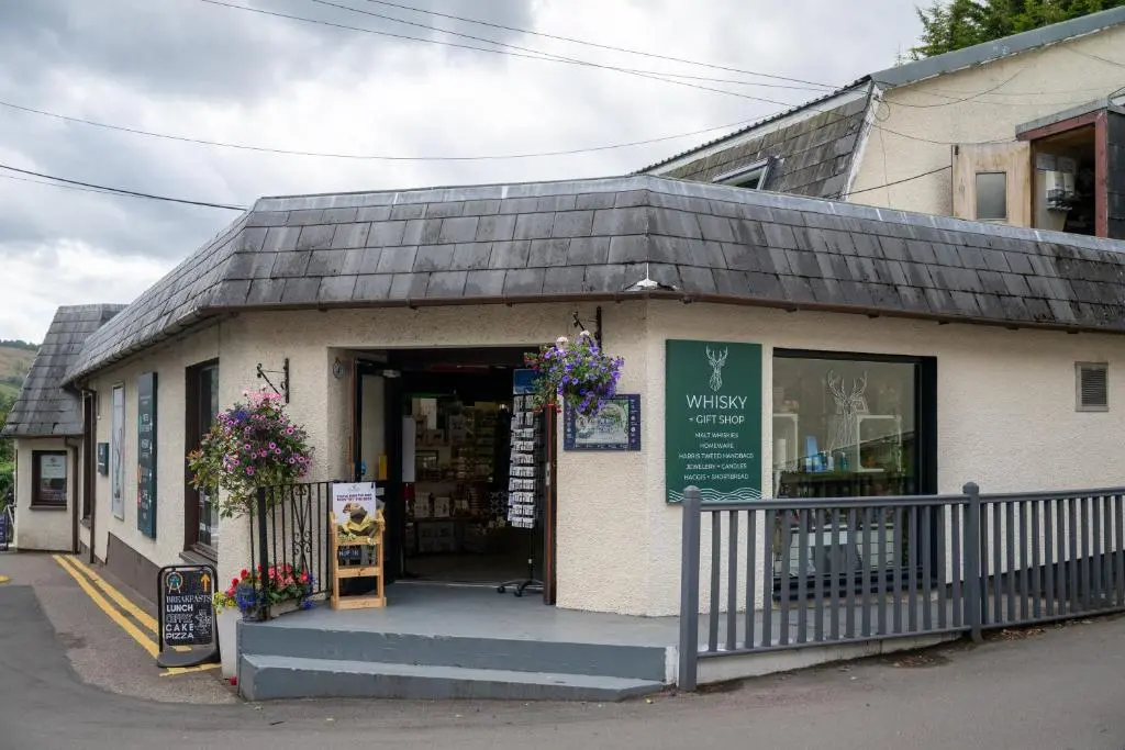 a book store with flowers on the front of it at Loch Ness Drumnadrochit Hotel in Drumnadrochit