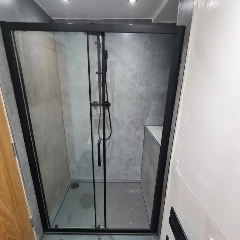 a shower with a glass door in a bathroom at Ness City Cottage - Attic Apartment in Inverness