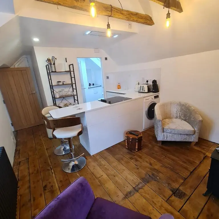 a kitchen with a counter and a table and chairs at Ness City Cottage - Attic Apartment in Inverness
