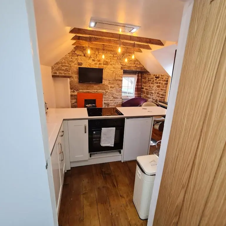 a kitchen with a sink and a stove top oven at Ness City Cottage - Attic Apartment in Inverness