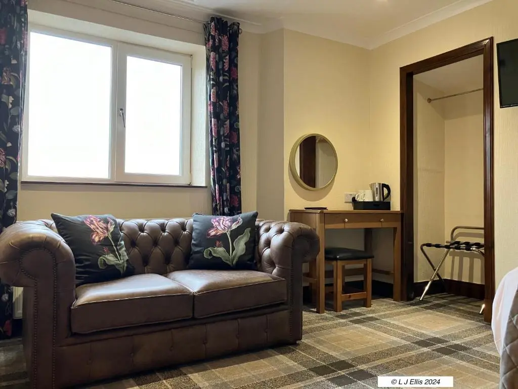 a living room with a couch and a window at Foyers House in Foyers