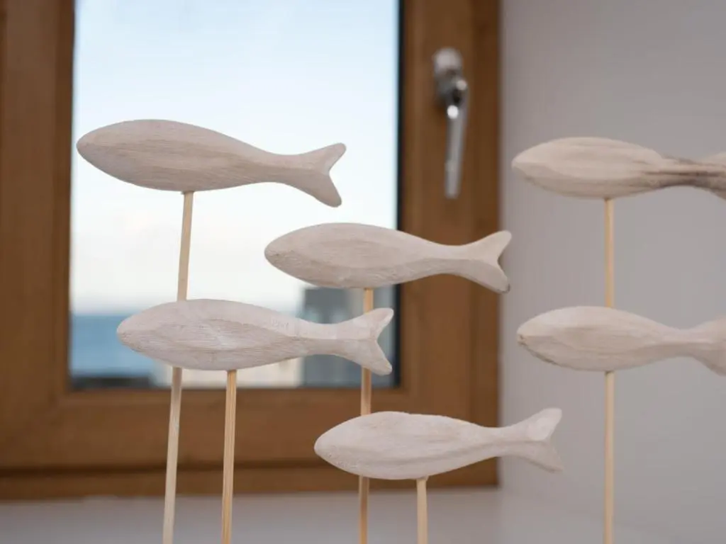 a group of wooden fish on sticks in front of a mirror at Apartment Harbour Nights Deluxe 7C by Interhome in Lossiemouth