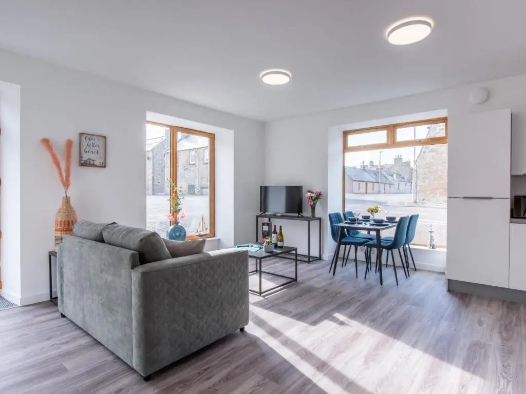 a living room with a couch and a table at Apartment Harbour Nights Deluxe Number 12 by Interhome in Lossiemouth