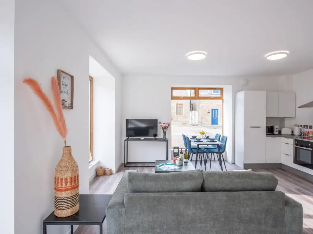 a living room with a couch and a table at Apartment Harbour Nights Deluxe Number 12 by Interhome in Lossiemouth
