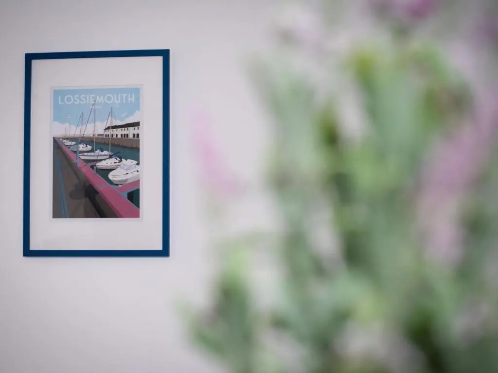 a picture hanging on a wall with a picture of boats at Apartment Harbour Nights Deluxe 7A by Interhome in Lossiemouth
