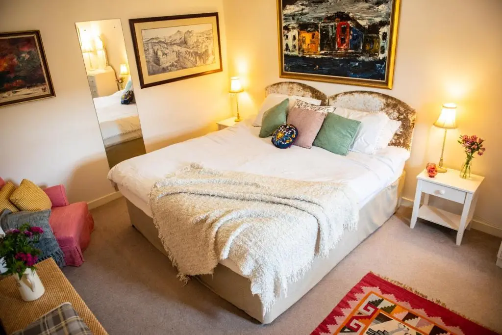 a bedroom with a bed and a mirror at Colmeallie Bothy - Seasgair Lodges in Brechin
