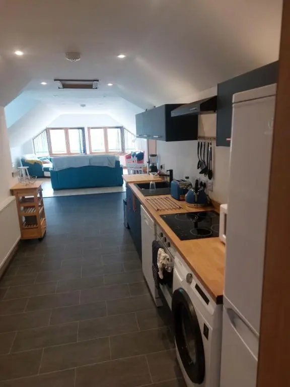 a kitchen with a washer and dryer in a room at Kiledinmuir in Tore