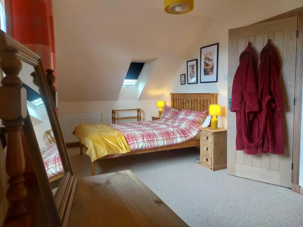 a bedroom with a bed and a wooden door at Kiledinmuir in Tore