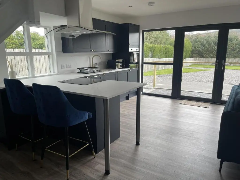 a kitchen with a large island with blue chairs at 4 Guests - Inverness Highland Hideaway Nc500 in Inverness