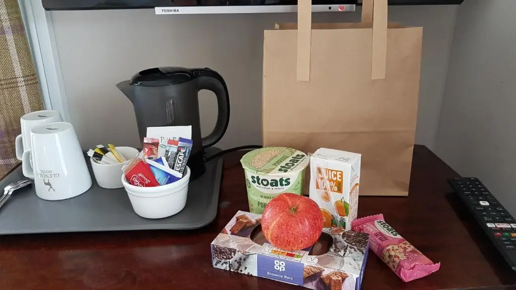 a counter with a coffee maker and some food on a table at Glenisla Hotel in Blairgowrie