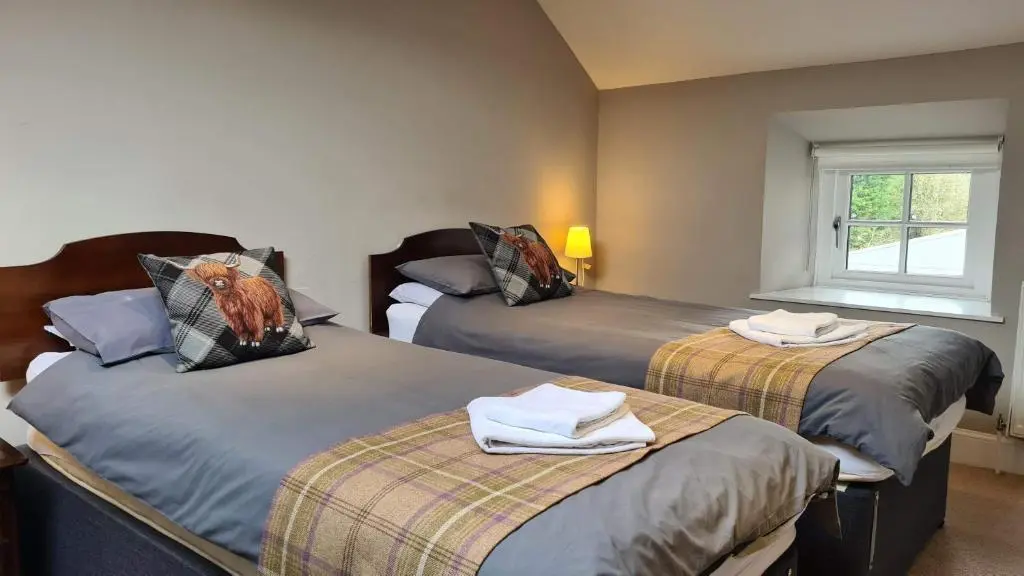 a bedroom with two beds with towels on them at Glenisla Hotel in Blairgowrie