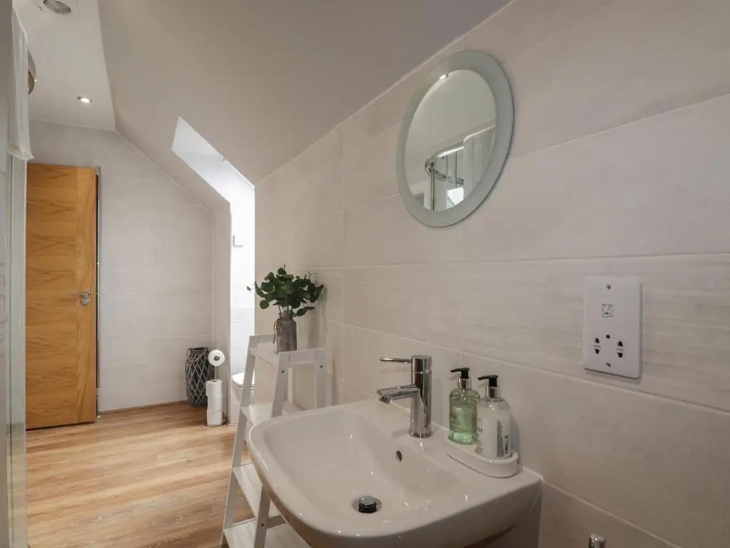 a white bathroom with a sink and a mirror at Spinnaker in Lossiemouth