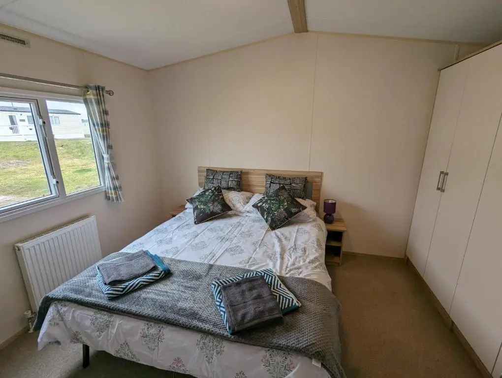a bedroom with a bed and a window at D11 - the Dunes at Silver Sands in Lossiemouth