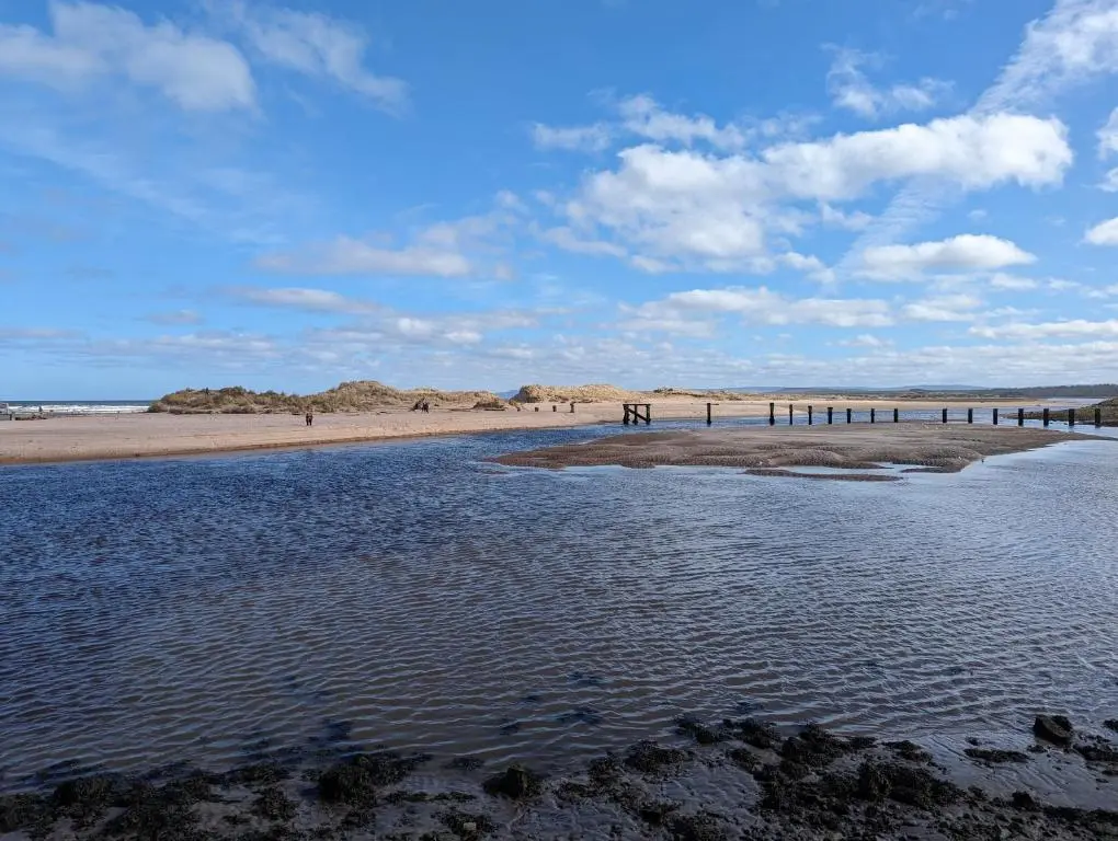 a beach with a body of water and a pier at D11 - the Dunes at Silver Sands in Lossiemouth